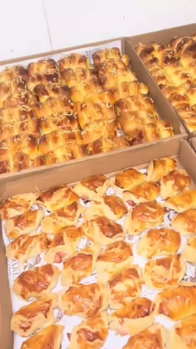Caixas de enroladinhos e croissants assados dourados, recém-saídos do forno da Dona Clara